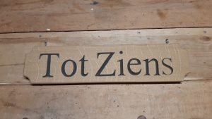 In hout gegraveerd "Tot Ziens"